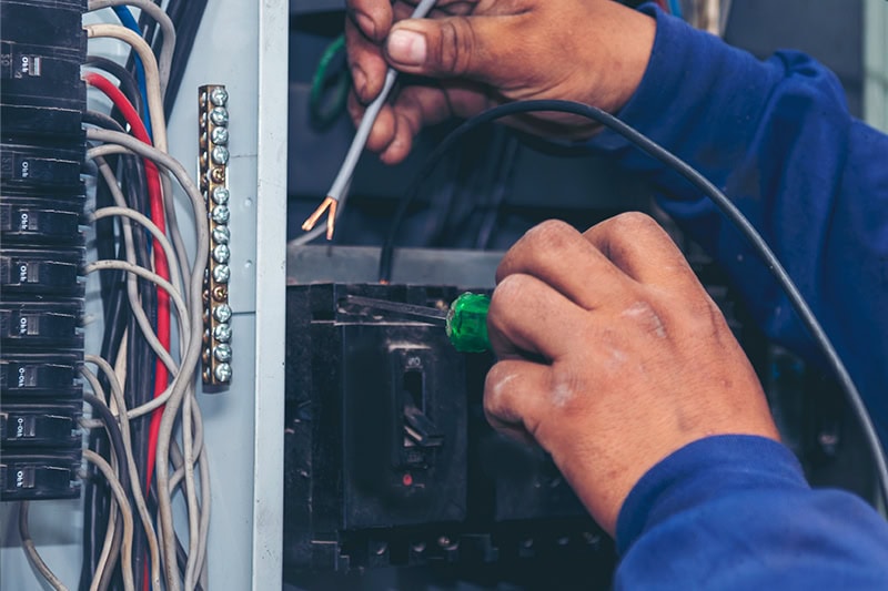 Upgrade Your Outdated Electrical Panel. An electrician working on an panel.